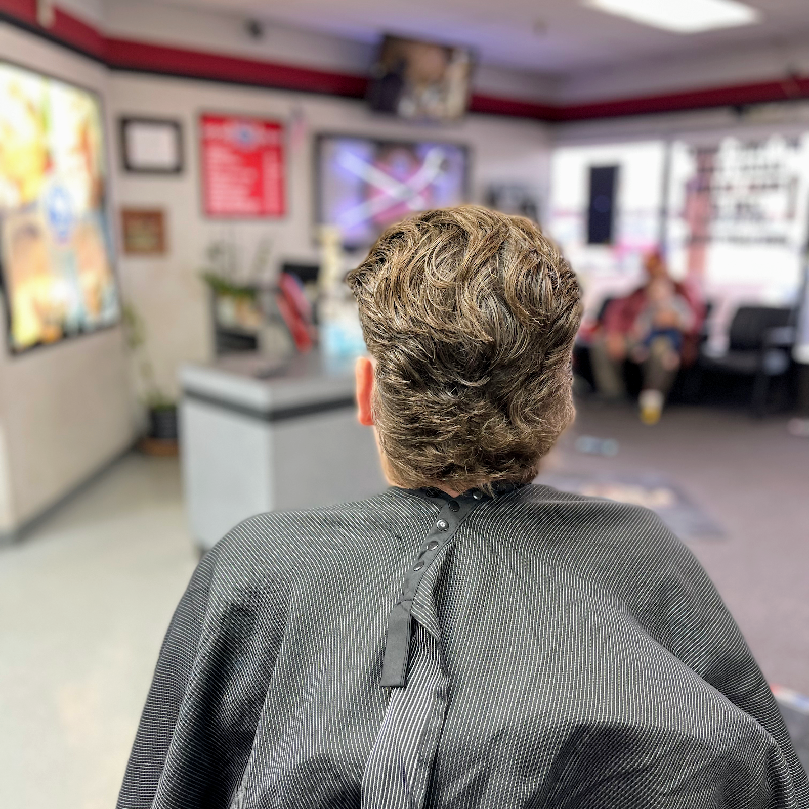 The back of a finished wavy flow cut, with the shop floor soft behind