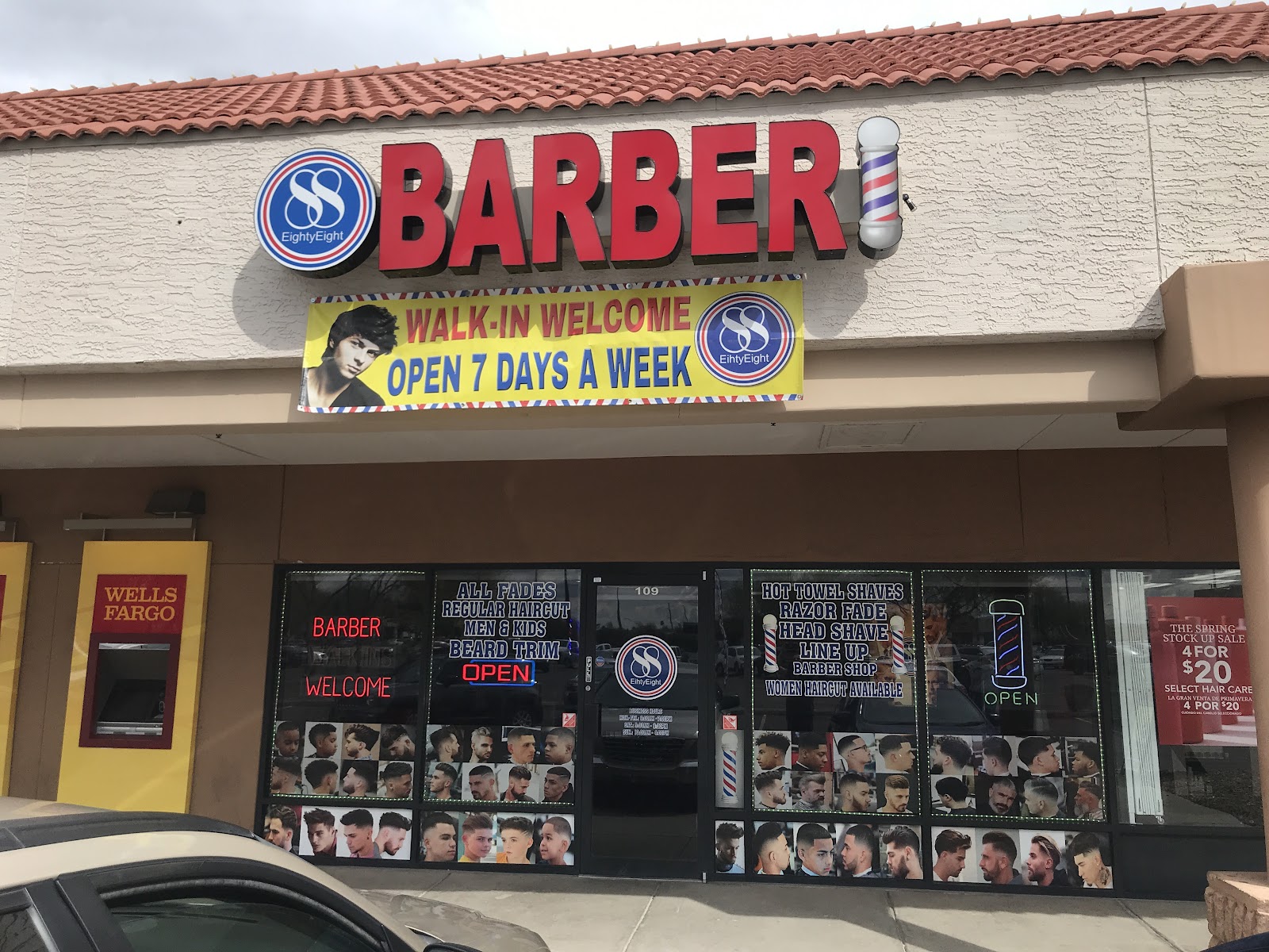 Barber 88's storefront in the Fry's plaza: big red BARBER letters, a barber pole on the fascia, and a walk-in welcome banner over suite 109